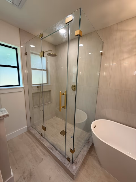 Frameless shower with brushed-brass hardware