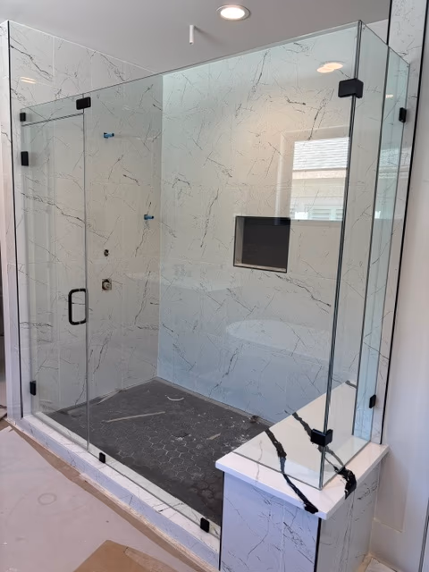Frameless walk-in shower with marble surround